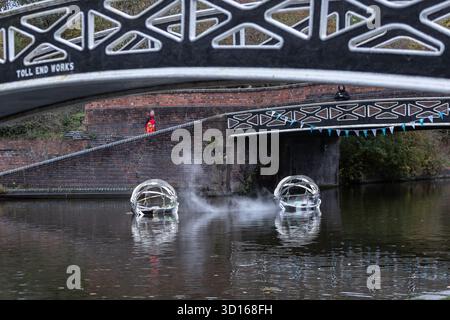 Dudley, West Midlands, Großbritannien. Oktober 2025. Eine faszinierende Flotte von drei beleuchteten, schwimmenden Skulpturen, Water Bots, an der Dudley No.2-Kanal-Kreuzung am Windmill End in der Nähe von Dudley im Herzen des industriellen Black Country, West Midlands. Der Künstler Michael Candy hat Water Bots als bahnbrechende Fusion von Kunst und Technik geschaffen. Es ist vom industriellen Erbe der Region West Midland inspiriert und wurde von Birmingham Open Media in Auftrag gegeben. Quelle: Peter Lopeman/Alamy Live News Stockfoto