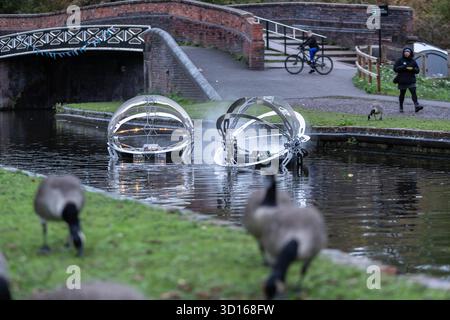 Dudley, West Midlands, Großbritannien. Oktober 2025. Eine faszinierende Flotte von drei beleuchteten, schwimmenden Skulpturen, Water Bots, an der Dudley No.2-Kanal-Kreuzung am Windmill End in der Nähe von Dudley im Herzen des industriellen Black Country, West Midlands. Der Künstler Michael Candy hat Water Bots als bahnbrechende Fusion von Kunst und Technik geschaffen. Es ist vom industriellen Erbe der Region West Midland inspiriert und wurde von Birmingham Open Media in Auftrag gegeben. Quelle: Peter Lopeman/Alamy Live News Stockfoto