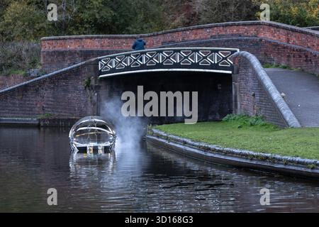 Dudley, West Midlands, Großbritannien. Oktober 2025. Eine faszinierende Flotte von drei beleuchteten, schwimmenden Skulpturen, Water Bots, an der Dudley No.2-Kanal-Kreuzung am Windmill End in der Nähe von Dudley im Herzen des industriellen Black Country, West Midlands. Der Künstler Michael Candy hat Water Bots als bahnbrechende Fusion von Kunst und Technik geschaffen. Es ist vom industriellen Erbe der Region West Midland inspiriert und wurde von Birmingham Open Media in Auftrag gegeben. Quelle: Peter Lopeman/Alamy Live News Stockfoto