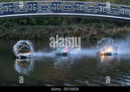 Dudley, West Midlands, Großbritannien. Oktober 2025. Eine faszinierende Flotte von drei beleuchteten, schwimmenden Skulpturen, Water Bots, an der Dudley No.2-Kanal-Kreuzung am Windmill End in der Nähe von Dudley im Herzen des industriellen Black Country, West Midlands. Der Künstler Michael Candy hat Water Bots als bahnbrechende Fusion von Kunst und Technik geschaffen. Es ist vom industriellen Erbe der Region West Midland inspiriert und wurde von Birmingham Open Media in Auftrag gegeben. Quelle: Peter Lopeman/Alamy Live News Stockfoto