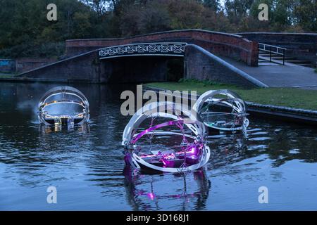 Dudley, West Midlands, Großbritannien. Oktober 2025. Eine faszinierende Flotte von drei beleuchteten, schwimmenden Skulpturen, Water Bots, an der Dudley No.2-Kanal-Kreuzung am Windmill End in der Nähe von Dudley im Herzen des industriellen Black Country, West Midlands. Der Künstler Michael Candy hat Water Bots als bahnbrechende Fusion von Kunst und Technik geschaffen. Es ist vom industriellen Erbe der Region West Midland inspiriert und wurde von Birmingham Open Media in Auftrag gegeben. Quelle: Peter Lopeman/Alamy Live News Stockfoto