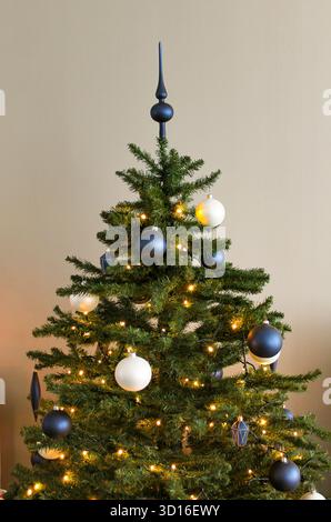Weihnachtsbaum mit Lichtern und Dekorationen in Blau und weiß Stockfoto