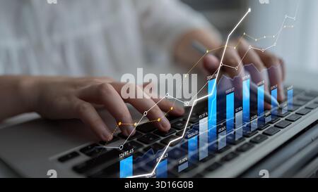 Ein Geschäftsmann arbeitet mit Finanzdaten auf einem Notebook. Die Abbildung zeigt Diagramme und Diagramme, die Wachstumstrends in einem modernen Arbeitsbereich darstellen. S Stockfoto