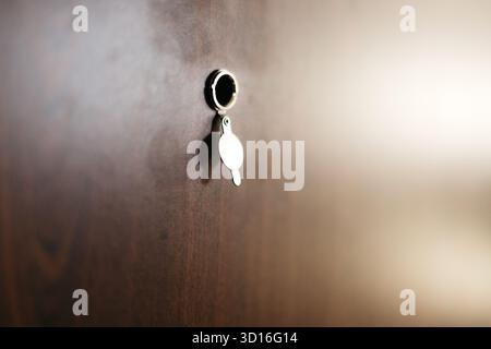 Durch ein Loch in der braunen Tür einer Wohnung Stockfoto