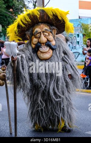 Person in aufwendigem „Xita“-Kostüm mit langem grauen Bart und übergroßer Maske während einer Xantolo-Parade (Tag der Toten) in San Luis Potosi, Mexiko. Stockfoto