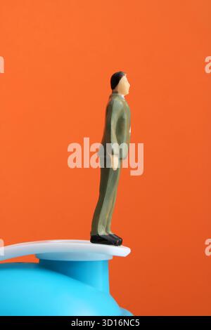 Führungskraft auf einem Trampolin, das Gleichgewicht hält Stockfoto