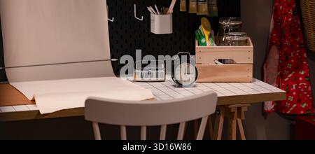 Minimalistische Einrichtung des Heimbüro-Schreibtisches mit Wecker-Rechner und Papierkorrektur auf weißem Tisch Stockfoto