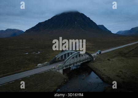 Fluss- und Straßenbrücke unter Buachaille Etive Mòr, Glencoe, schottische Highlands, an einem bewölkten Herbsttag. Stockfoto