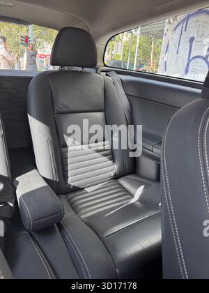 Schwarzer Ledersitz im Sonnenlicht im geparkten Fahrzeug. Komfort, Transport-Lifestyle und modernes Design im Alltagsleben. Stockfoto