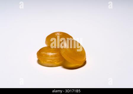 Arzneimittel, drei runde gelbe Tabletten auf weißem Hintergrund, übereinander angeordnet. Stockfoto