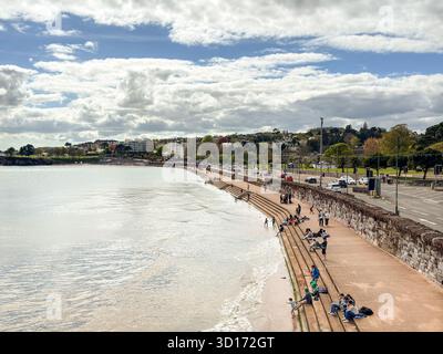 Torquay, Devon, England, Großbritannien - 23. april 2025: Menschen am Meer in Torquay, einem Ferienort im Südwesten Englands. Stockfoto
