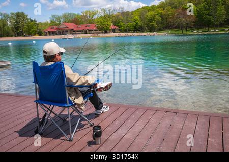 Fayetteville, NY USA - 15. Mai 2019: Man Sitting Oon Dock im Green Lakes State Park. Stockfoto