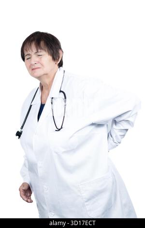 Oberarzt spürt starke Rückenschmerzen, hält den unteren Rücken mit den Händen, spürt Unbehagen beim Stehen, trägt einen weißen Labormantel Stockfoto