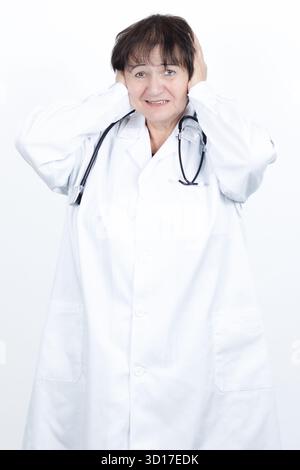 Überforderte Ärztin, die sich unter extremen Druck befindet, Stress und Burnout erlebt, Ohren bedeckt, um unerwünschte Geräusche auszublenden Stockfoto