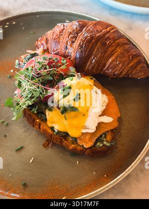 Französisches Croissant mit Räucherlachs, pochiertem Ei und Hollandaise-Sauce Stockfoto