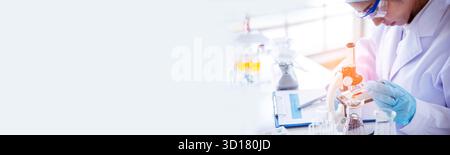 Banner Asiatische Frau Wissenschaftlerin Hand schreiben Notiz Forschung im medizinischen Labor Blick auf Wissenschaft Mikroskop. Panorama-Biologie-Chemielabor. Asiatische weibliche Technici Stockfoto