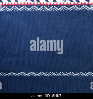 Horizontaler oder vertikaler Weihnachtshintergrund mit gestrickter Textur. Wollpullover-Textur in dunkelblauer Farbe mit weißem Rand. Naturgestrickter Arbeitsauftrag Stockfoto