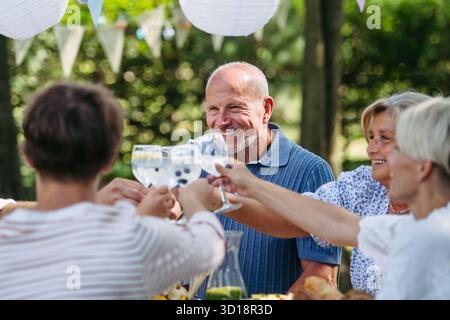 Generationenübergreifende Familientoasten während einer Grillparty im Freien. Stockfoto