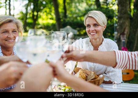Generationenübergreifende Familientoasten während einer Grillparty im Freien. Stockfoto