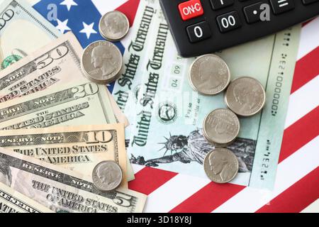 US-Dollar-Geldscheine und Taschenrechner auf amerikanischer Flagge Nahaufnahme. Geldinvestitionskonzept und Steuerzahlung Stockfoto