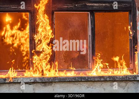 Feuerwehrmann, der ein Baby aus dem brennenden Gebäude rettet, Feuerwehrmann in Aktion Kind retten, Notfallsituation, Feuer im Haus, Gefahr, Rettungsaktion Stockfoto
