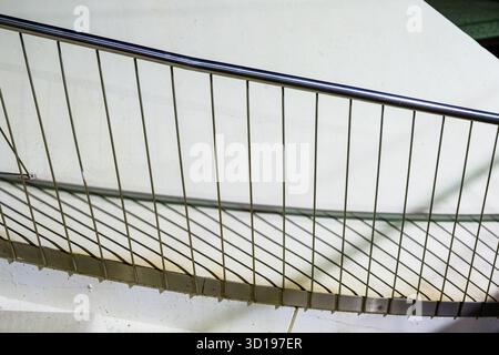 Detailliertes Schattenspiel auf geschwungenem Treppengeländer Stockfoto
