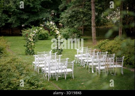 Hochzeitszeremonie im Freien mit Blumenbogen Stockfoto