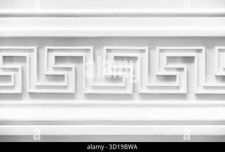 Dekoration mit weißem Meander-Motiv. Klassische Wandverkleidung, Innendetails im Vintage-Stil, abstrakter architektonischer Hintergrund, Schwarz-weiß Stockfoto