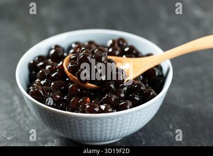Eine Schüssel Black Boba Tapioca Pearls, belegt mit Bubble Bobba Milk Tea und anderem Dessert Stockfoto