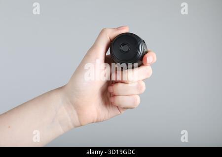 Frau mit versteckter Spionageschiene auf hellgrauem Hintergrund, Nahaufnahme Stockfoto