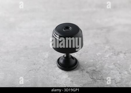 Moderne, versteckte Spionageskamera auf hellgrauem Tisch, Nahaufnahme Stockfoto
