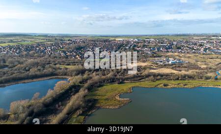 Drohnenblick über die Nene Wetlands und Irthlingborough Lakes mit Seen und Wiesen in Northamptonshire, England. Higham Ferrers im Hintergrund. Stockfoto