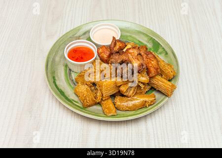 Frittierte und goldene Yuca-Stücke, perfekt kombiniert mit peruanischer ají amarillo und Huacatay-Creme Stockfoto
