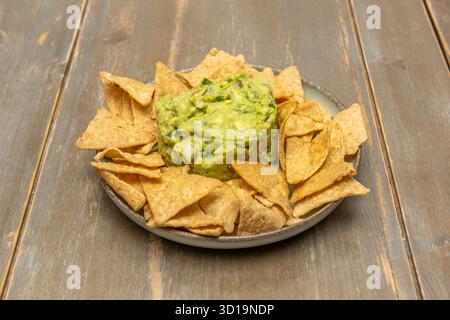 Gemischte Nachos mit Schichten verschiedener Aufschnitt, Käse und Salsas auf einer großen Platte Stockfoto