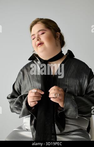 Eine fröhliche junge Frau mit Down-Syndrom zeigt ihren einzigartigen Stil, während sie in einem schicken Outfit lächelt. Stockfoto