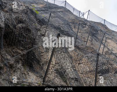 Stahlschutznetze, die als Steinschlagbarriere in den Bergen verwendet werden, um herabfallende Felsen zu verhindern. Stockfoto