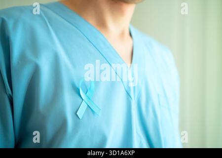Arzt in medizinischer Kleidung mit blauem Band auf der Brust symbolisiert November Prostatakrebs Bewusstsein und Früherkennung für rechtzeitige medizinische Versorgung. Stockfoto