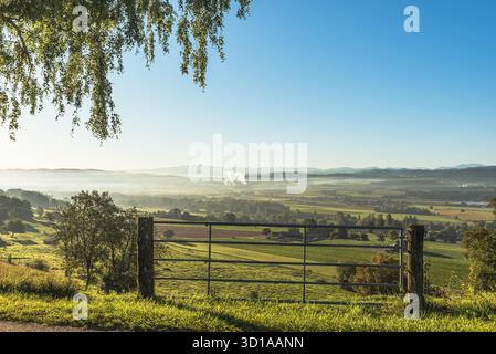 Ländliche Morgenstimmung im Schweizer Kanton Thurgau: Saftig grüne Wiesen, ein Zaun und im Hintergrund das Thurtal. In der Ferne erhebt sich die Silhouette des Alpsteins mit dem Säntis über den Horizont. Stockfoto