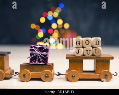 Gott Jul, Scaninavian Merry Christmas mit einem kleinen hölzernen Zug Set mit Geschenkbox auf verschwommenen Weihnachtslichtern, saisonaler oder weihnachtlicher Hintergrund Stockfoto