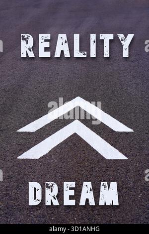 Evolution von Traum- zu Reality-Konzepten. Worte auf dem Asphalt mit Pfeilen des Fortschritts oder Wachstums Stockfoto