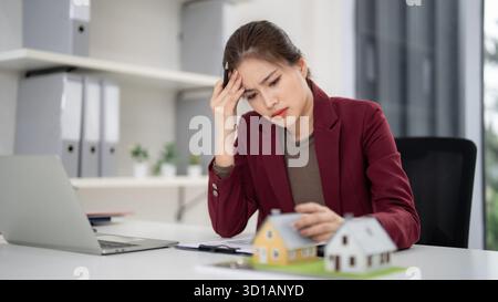 Professionelle Erwachsene asiatische Frau Immobilienmaklerin fühlt sich gestresst bei der Handhabung von Immobilienverkäufen Geschäfte Büroschalter Stockfoto