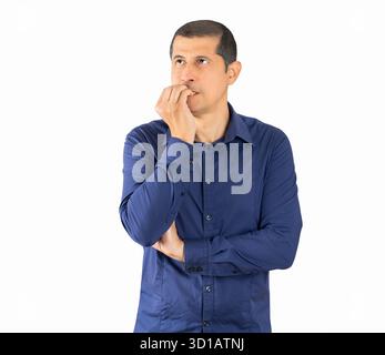 Geschäftsmann mit blauem Hemd, der gestresst und nervös aussieht, mit Händen auf dem Mund beißenden Nägeln. Angstproblem. Stockfoto