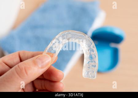 Frau Hand mit Silikontrainer in einem Badezimmer mit einer blauen Box im Hintergrund Stockfoto