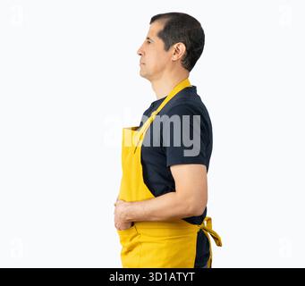 Hispanischer Barista mit gelber Schürze über isoliertem Hintergrund und Blick zur Seite, entspannende Profilposition mit natürlichem Gesicht mit selbstbewusstem Lächeln und positivem Emoti Stockfoto