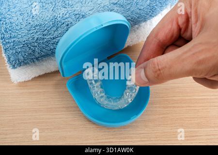 Draufsicht auf die Frauenhand mit Silikontrainer in einem Badezimmer mit blauer Box zu Hause Stockfoto