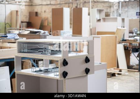 Holzwerkstatt mit verschiedenen Werkzeugen, Möbelteile im Vordergrund Stockfoto