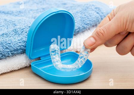 Frau Hand mit Silikontrainer in einem Badezimmer mit blauer Box zu Hause Stockfoto