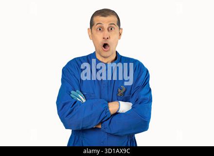 Hispanischer Mann über weißem Hintergrund in mechanischer Uniform, erschreckt vor Schock mit einem überraschenden Gesicht, ängstlich und aufgeregt vor Angstausdruck Stockfoto