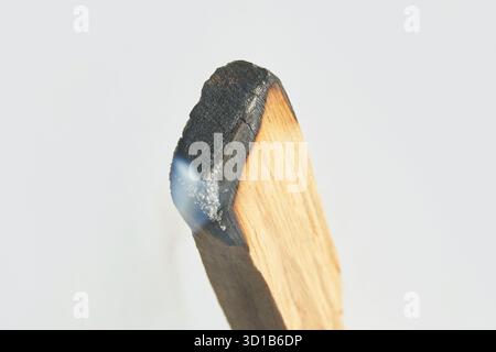 Nahaufnahme eines brennenden palo santo-Sticks mit Rauch auf weißem Hintergrund. Stockfoto