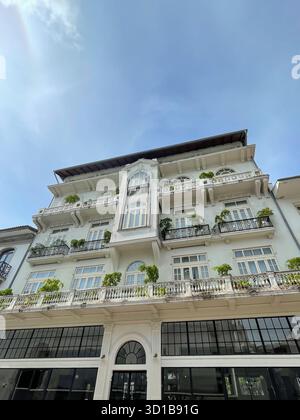 Fassade im Kolonialstil in Casco Viejo, Panama City, weiße Wände und Bogenfenster, Balkone mit Pflanzen. Flachwinkelansicht Stockfoto
